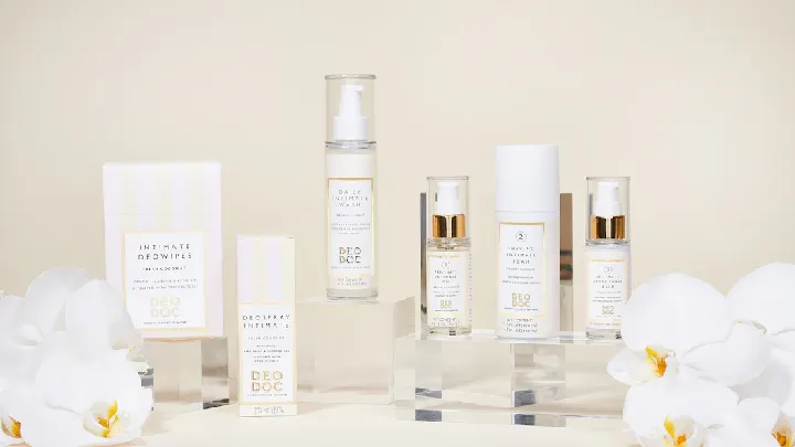 A collection of skincare products displayed with white flowers.